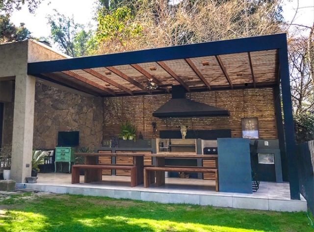 Quincho con parrilla, campana y mesones bajo techo de quincha